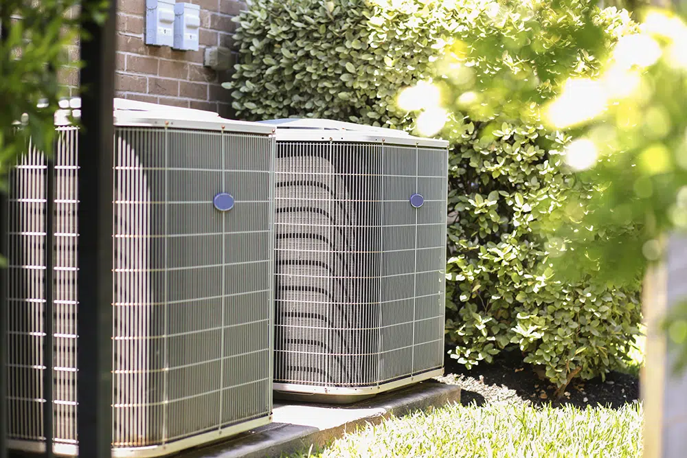 Outdoor air conditioning condenser units installed beside a home in the Wilson, NC region.
