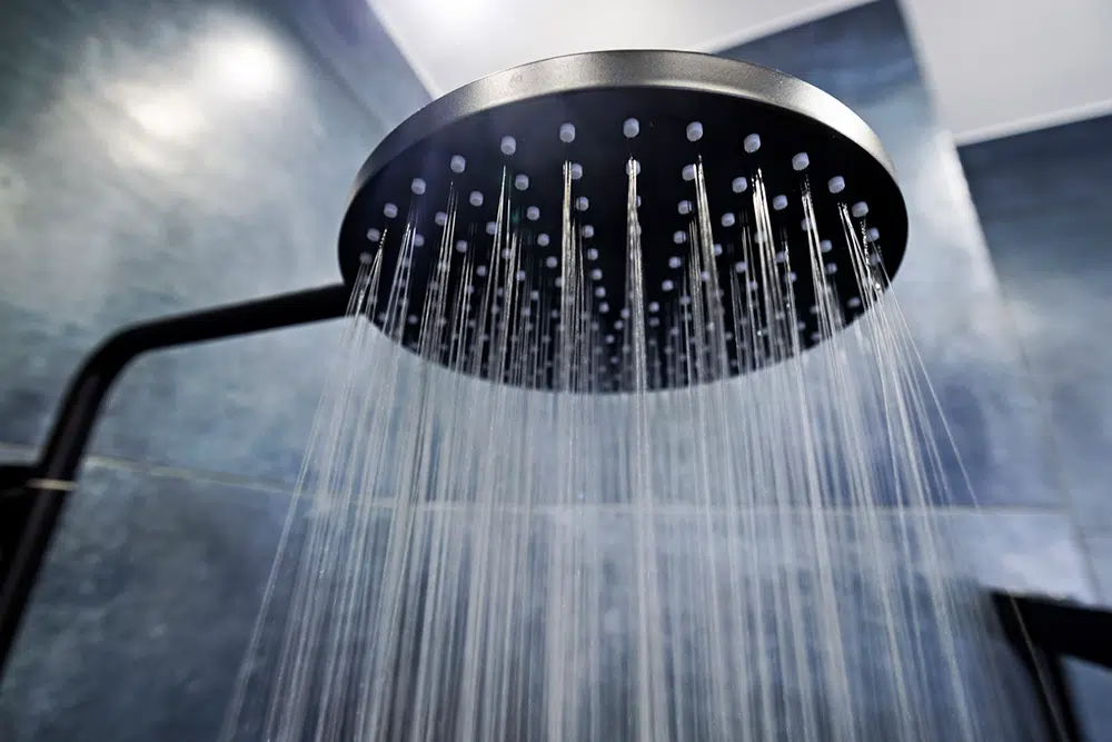 Water flowing from a rainfall showerhead in a contemporary Wilson, NC bathroom.