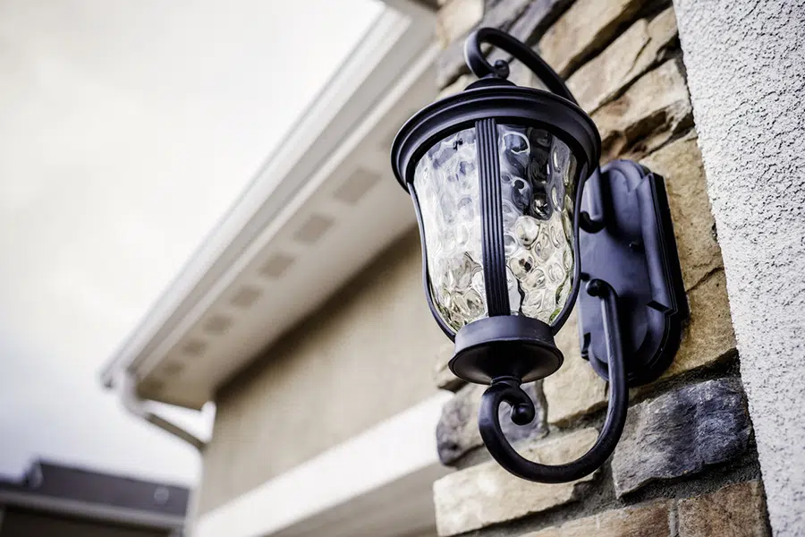 Decorative outdoor wall sconce lighting fixture installed on a brick home in the Wilson area.