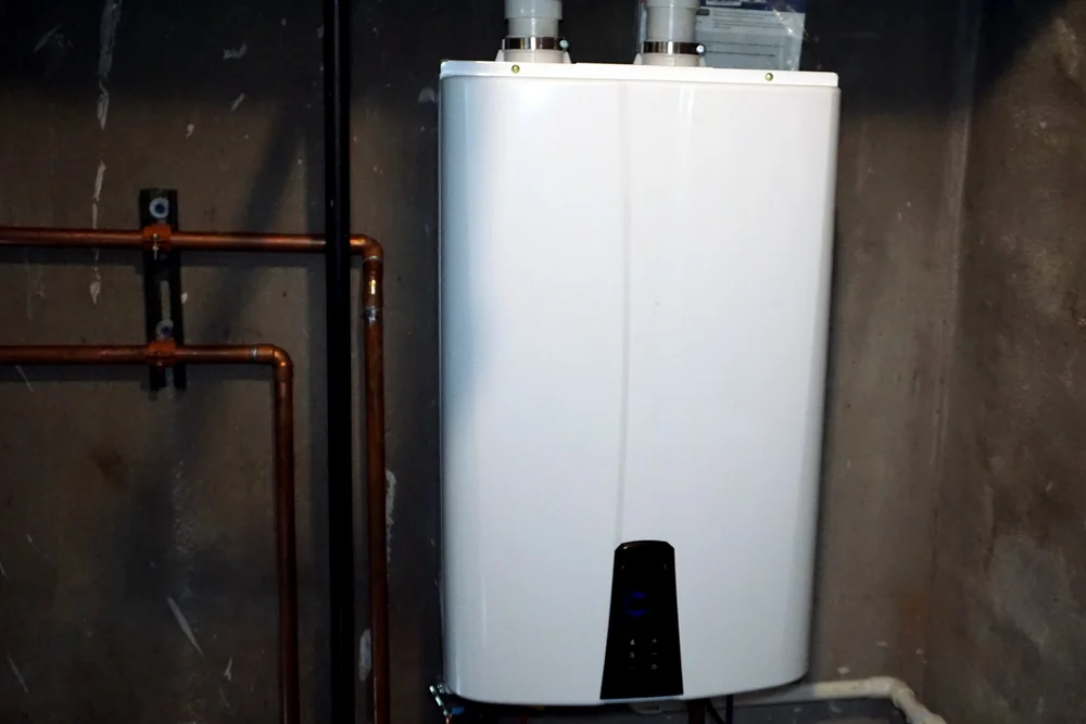 Modern tankless water heater installed on a wall in a Wilson, North Carolina utility space.