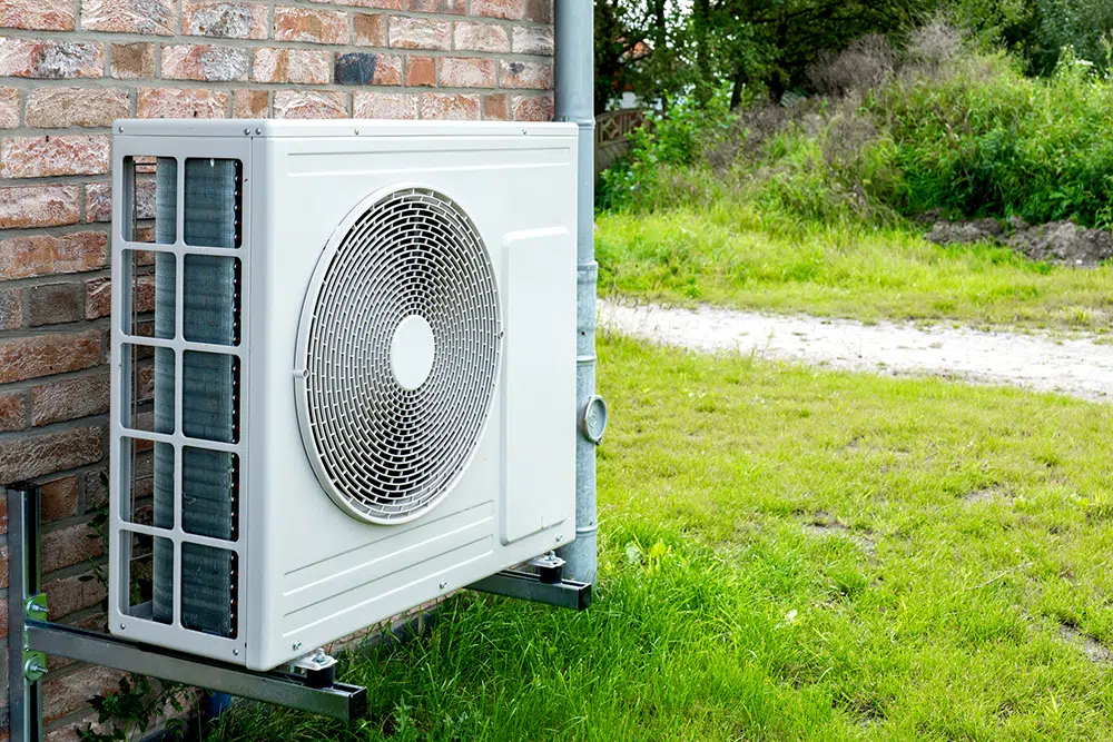 Ductless HVAC condenser installed on a brick exterior wall in greater Wilson, North Carolina.